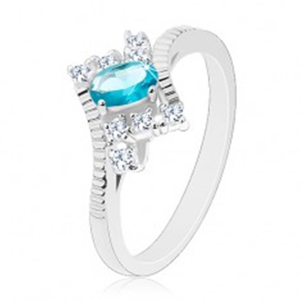 Šperky eshop Prsteň v striebornej farbe, oválny svetlomodrý zirkón, zárezy na ramenách - Veľkosť: 50 mm